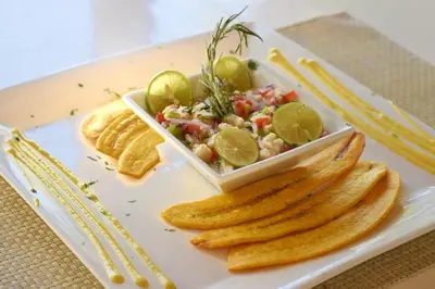 a white plate with a salad and a bowl of food at Puerto Blanco Marina & Hotel in Puerto de Luperon