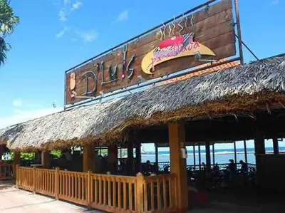 a restaurant with a straw roof and a sign at Cerca del Mar, Obelisco Hembra y Zona Colonial in Santo Domingo