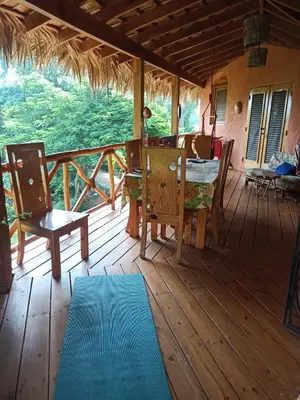 a porch of a house with a table and chairs at La Casa Del Arbol in Las Galeras
