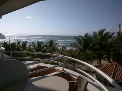 a balcony with a view of the ocean at Aparta Hotel Caribe Paraiso in Juan Dolio