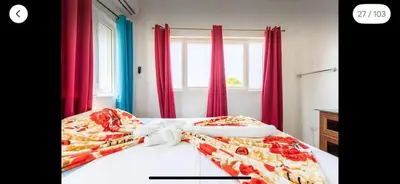 a bedroom with a large bed with red curtains at Villa Vista azul Sosua in Sosúa