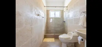 a bathroom with a toilet and a sink and a shower at Villa Vista azul Sosua in Sosúa