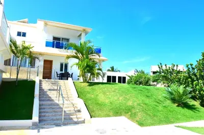 a large white house with a grassy yard at Villa Vista azul Sosua in Sosúa