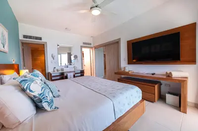a bedroom with a large bed and a flat screen tv at Presidential Suites Cabarete - Room Only in Cabarete
