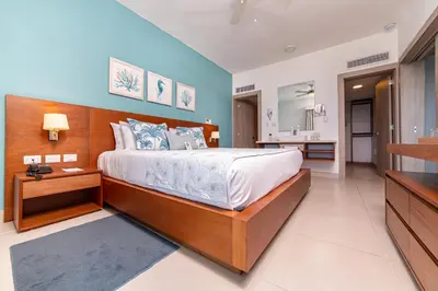 a bedroom with a large bed and a bathroom at Presidential Suites Cabarete - Room Only in Cabarete