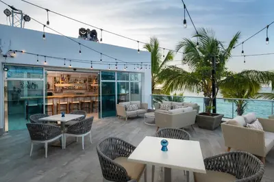 a patio with tables and chairs and a bar at Presidential Suites Cabarete - Room Only in Cabarete