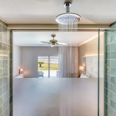 a bathroom with a mirror and a ceiling fan at Senator Puerto Plata in San Felipe de Puerto Plata