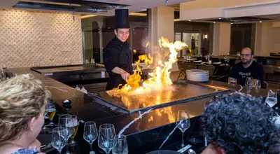 a chef standing in a restaurant with a fire pit at Senator Puerto Plata in San Felipe de Puerto Plata