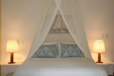 a bedroom with a white bed with two lamps at Caribbean Beach Villa Playa Bonita Las Terrenas in Las Terrenas