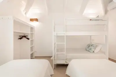 two beds in a room with white walls at Caribbean Beach Villa Playa Bonita Las Terrenas in Las Terrenas