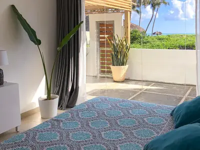 a room with a bed and a window with plants at Residencial Mañanero in Cabarete