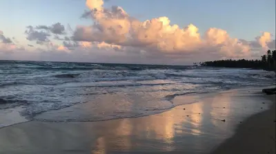 a beach with the ocean and clouds in the sky at Baoba Breeze Bed & Breakfast- beachfront paradise in Cabrera