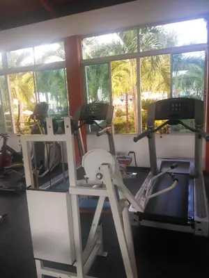 a gym with three tread machines and a window at PARADISE 3 Cerro Altos in Santiago de los Caballeros