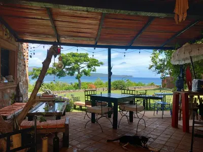a patio with a table and a cat laying on the ground at El Castillo in Las Galeras