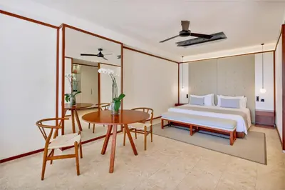 a bedroom with a bed and a table and chair at Live Aqua Punta Cana - All Inclusive - Adults Only in Punta Cana