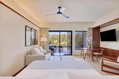 a bedroom with a bed and a living room at Live Aqua Punta Cana - All Inclusive - Adults Only in Punta Cana