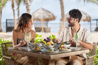 a man and woman sitting at a table with food at Live Aqua Punta Cana - All Inclusive - Adults Only in Punta Cana