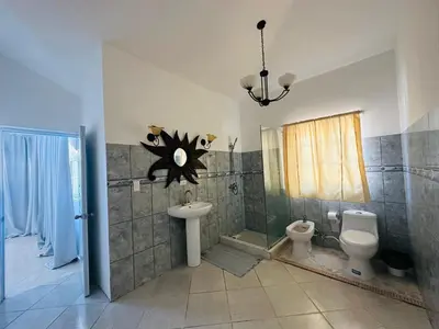 a bathroom with a sink and a toilet and a shower at HappiCasaRD & Holistic House in Sosúa