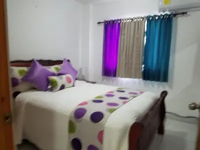 a bedroom with two beds with purple and purple pillows at Ave. Duarte k3/12, Residencial Palma Real, Santiago, RD in Arenoso