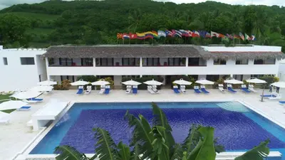 a resort with a large swimming pool and umbrellas at Oasi Encantada - Beach Resort in Santa Cruz de Barahona