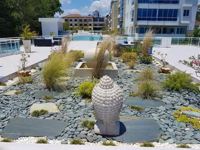 a garden with a statue in the middle of a yard at Koko and Suzy's ocean dream in Laguna del Higüero