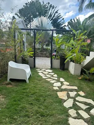 a garden with a white bench and some plants at El Rincon de Abi in Las Terrenas