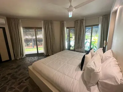 a bedroom with a large white bed with windows at El Rincon de Abi in Las Terrenas