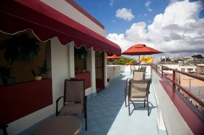 a balcony with chairs and tables and an umbrella at Hotel Discovery in Santo Domingo