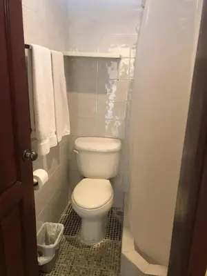 a small bathroom with a toilet and towels at Hotel Discovery in Santo Domingo