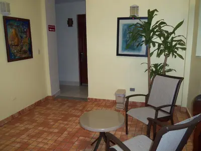 a room with chairs and a table and a plant at Hotel Discovery in Santo Domingo