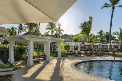 a pool at the resort with chairs and umbrellas at Dreams La Romana All-Inclusive Resort & Spa in Bayahibe