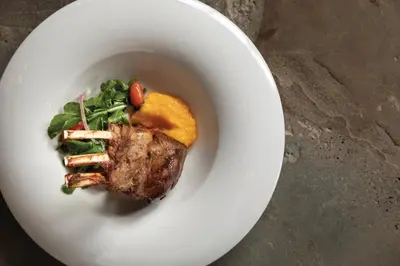 a plate of food with a piece of meat and greens at Secrets La Romana All-Inclusive Adult Only Resort & Spa in Bayahibe