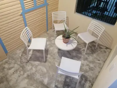 a group of white chairs and a table and a plant at El Conde de Villa Rosa in Salado