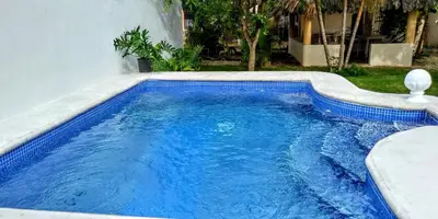 a swimming pool with blue water in a yard at El Conde de Villa Rosa in Salado