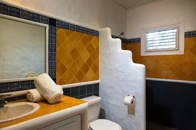 a bathroom with a sink and a toilet and a mirror at Condo Hotel Playa Las Ballenas in Las Terrenas