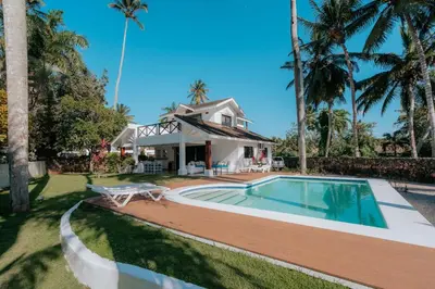 a home with a swimming pool and a house at Condo Hotel Playa Las Ballenas in Las Terrenas
