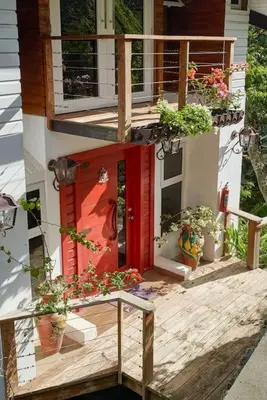 a house with a red door and some potted plants at Mansion Dubai-Mountain-Jacuzzi-4BR-Jamaca De Dios in Jarabacoa