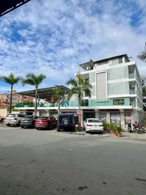a parking lot with cars parked in front of a building at Hotel Restaurant Hamilton in Boca Chica