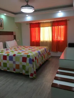 a bedroom with a bed with a colorful blanket at Hotel Restaurant Hamilton in Boca Chica