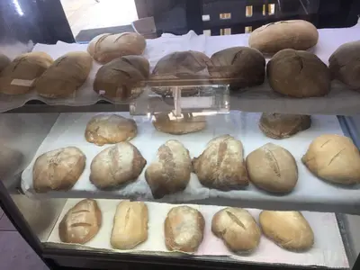 a display case filled with lots of loaves of bread at Hotel Restaurant Hamilton in Boca Chica