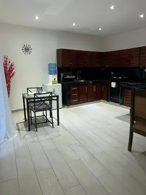 a kitchen with wooden cabinets and a table and chairs at Villa Kate in Las Terrenas