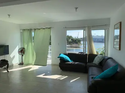 a living room with a couch and a large window at Mirador Colonial, en el Residencial Riviera Colonial in Santo Domingo