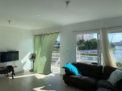 a living room with a couch and a large window at Mirador Colonial, en el Residencial Riviera Colonial in Santo Domingo