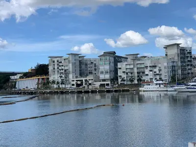 a group of apartment buildings next to a body of water at Mirador Colonial, en el Residencial Riviera Colonial in Santo Domingo