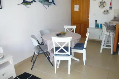 a white table and chairs in a kitchen with a table at Cadaques Caribe Boulevard Dominicus Americanus Carretera a Bayahibe Vel 206 in Bayahibe