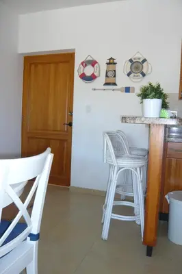 a kitchen with white stools and a counter top at Cadaques Caribe Boulevard Dominicus Americanus Carretera a Bayahibe Vel 206 in Bayahibe
