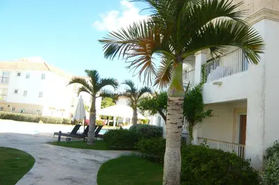 a palm tree in front of a building at Cadaques Caribe Boulevard Dominicus Americanus Carretera a Bayahibe Vel 206 in Bayahibe