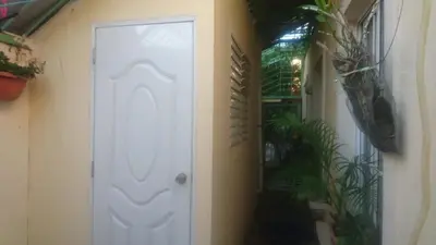 a white door in a hallway with a plant at MiniHabitacion coqueta in Santo Domingo