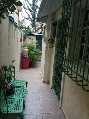 an alley with two green chairs and a balcony at MiniHabitacion coqueta in Santo Domingo