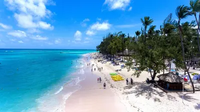 a group of people on a beach with the ocean at Hotel Checkin El Cortecito Beach in Punta Cana